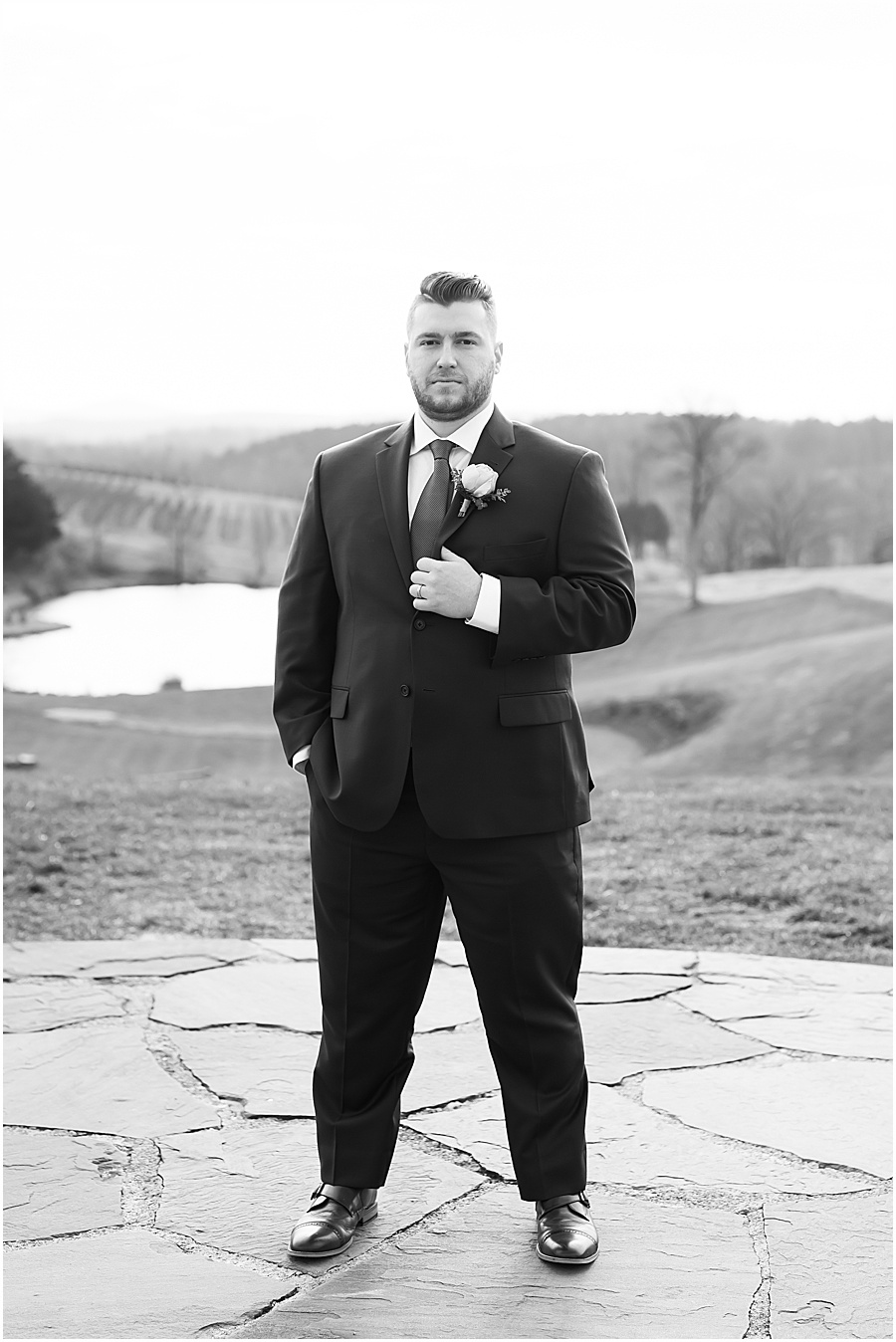 black and white groom portrait at stone tower 