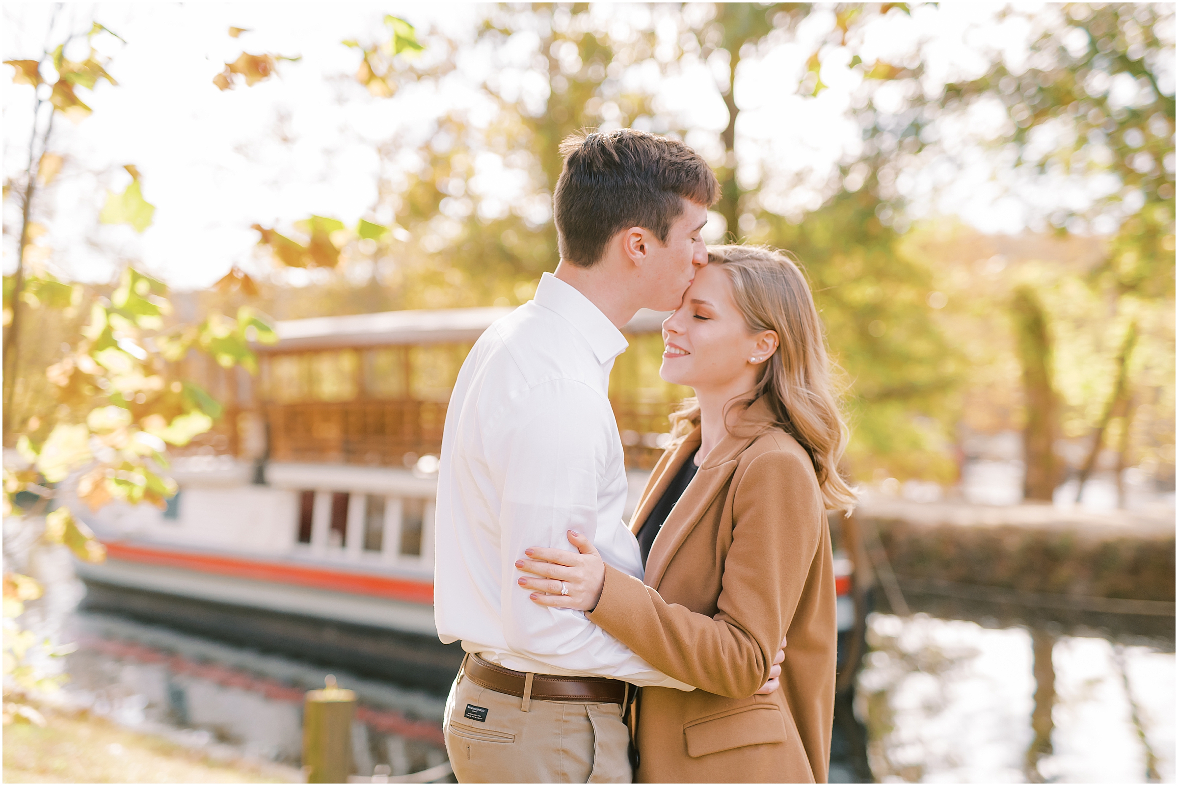 Couple kissing on forehead autumn engagement session at Great Falls