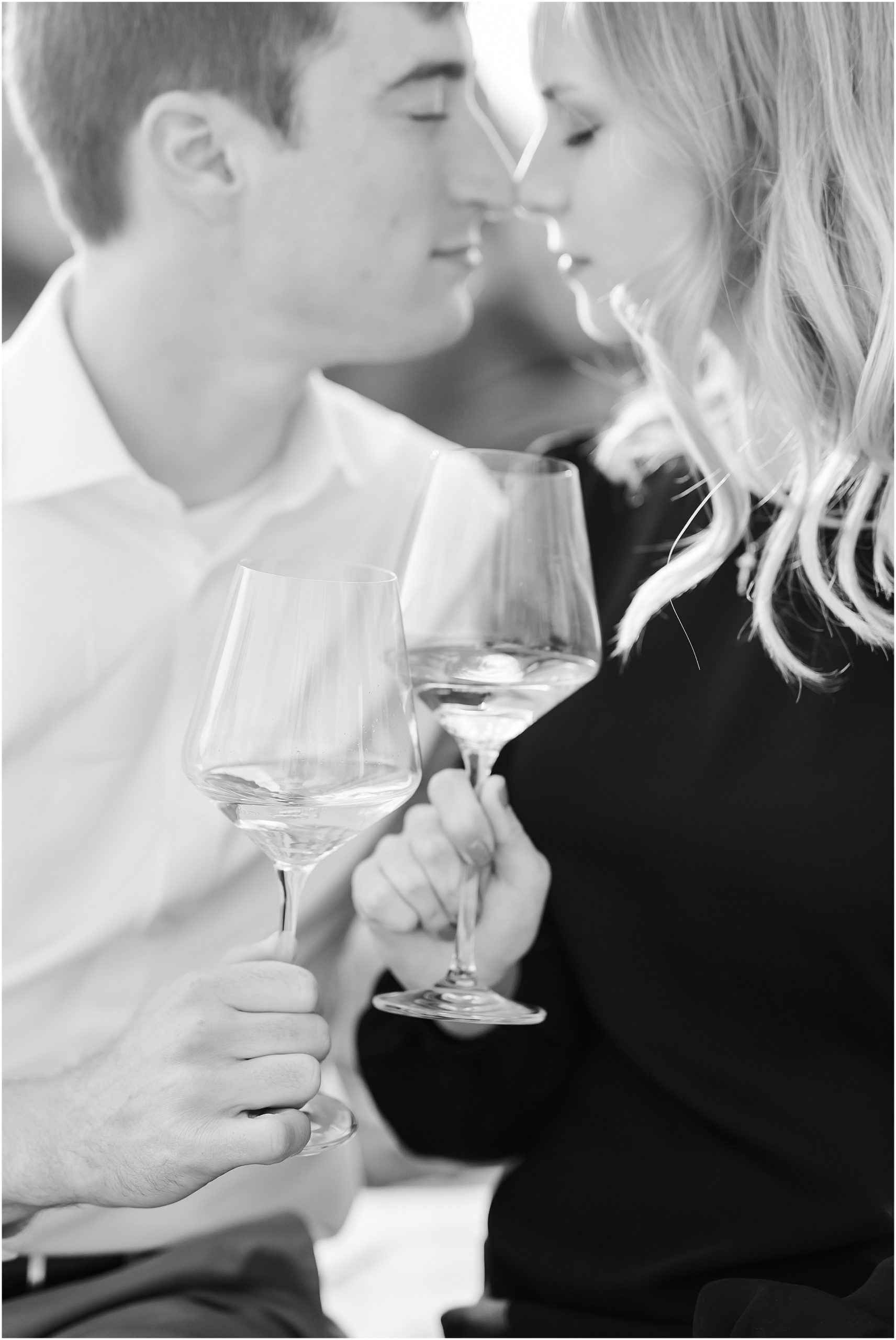Couple sharing glasses of wine during engagement session