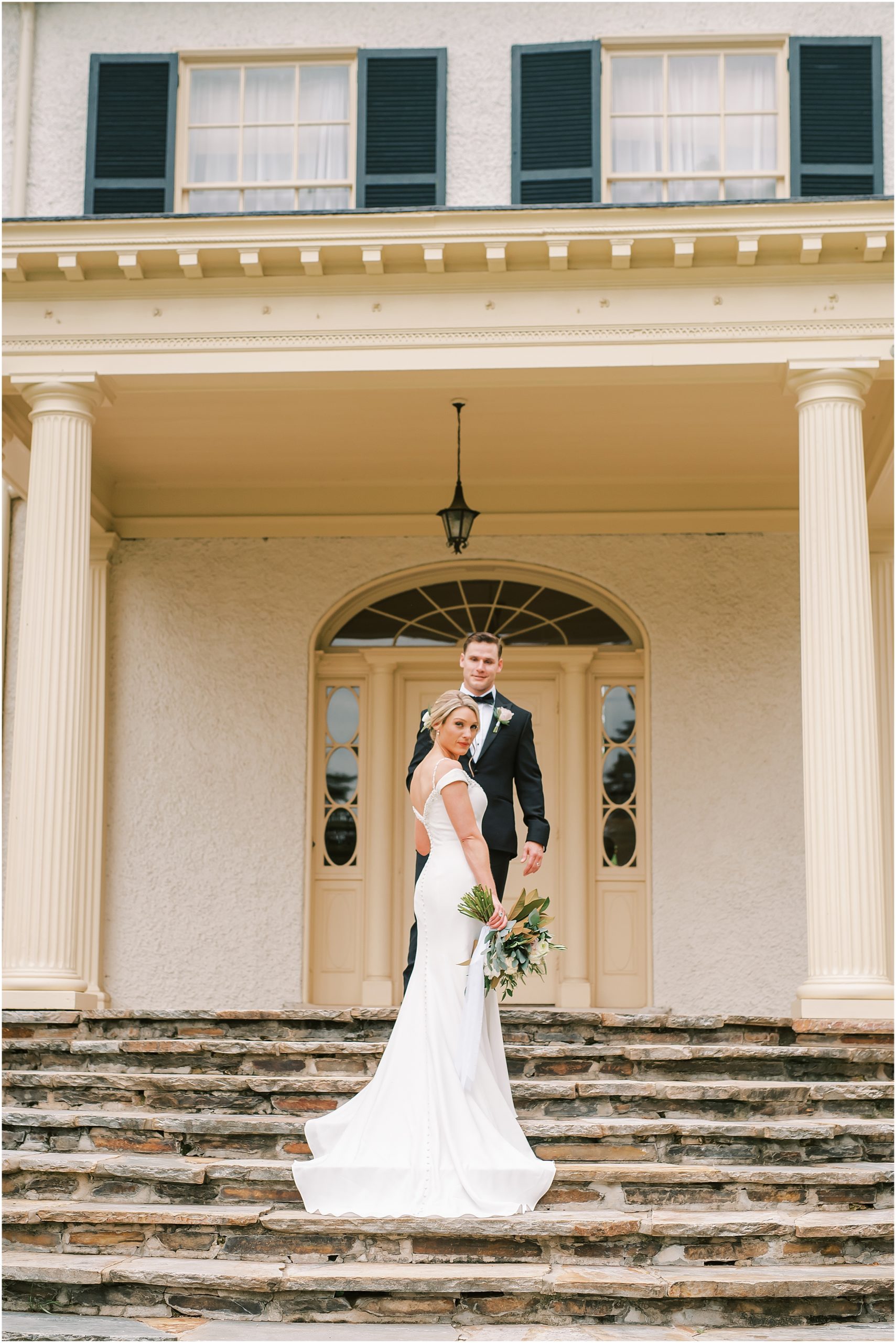 Bride and groom on steps of Rust Manor House