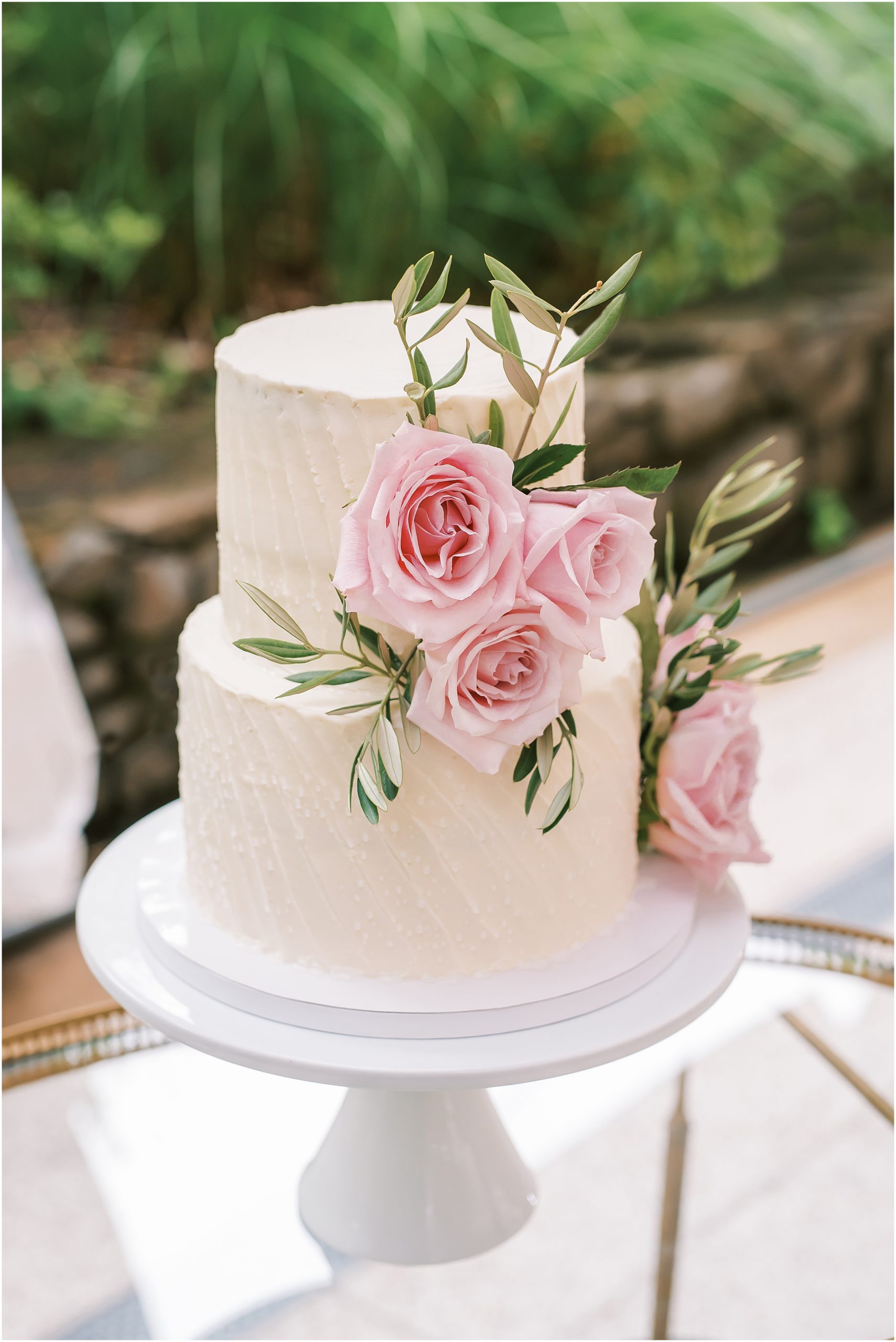 White two-tier wedding cake with pink roses