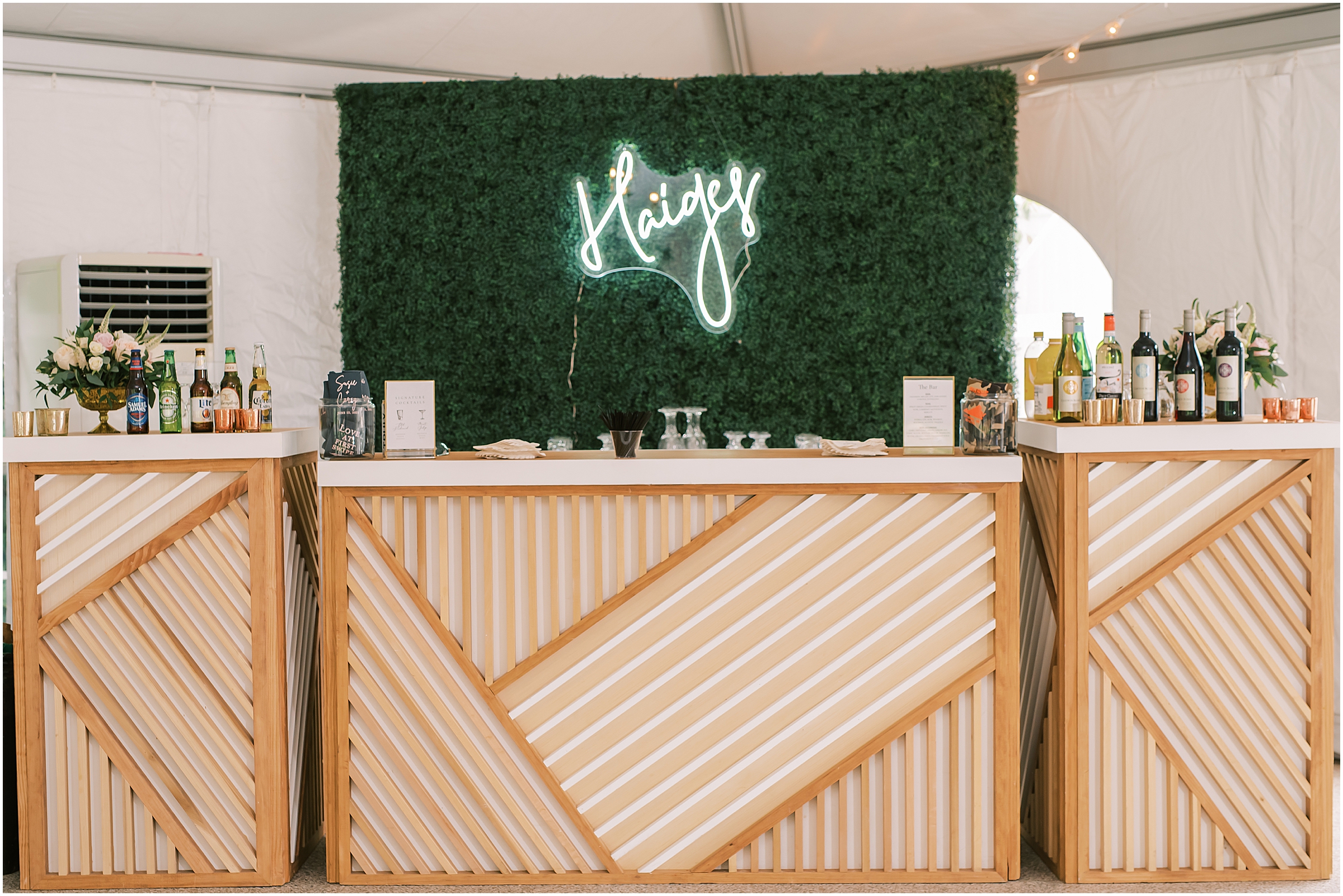 Wedding reception bar with grass wall and neon sign