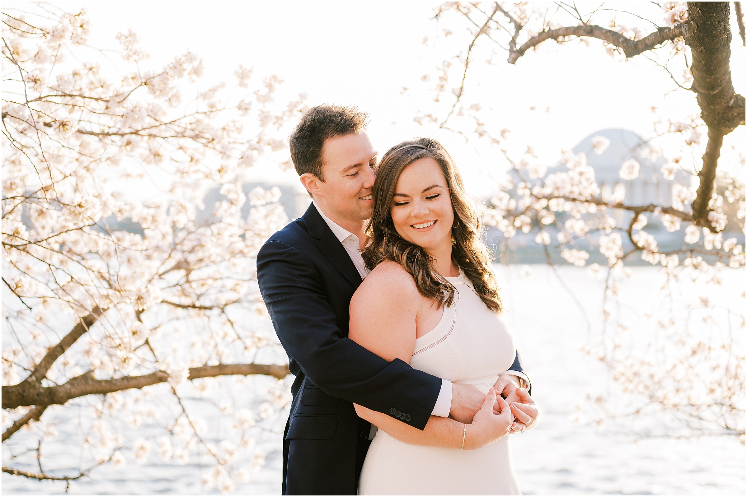Couple embracing in front of cherry blossoms in Washington D.C.