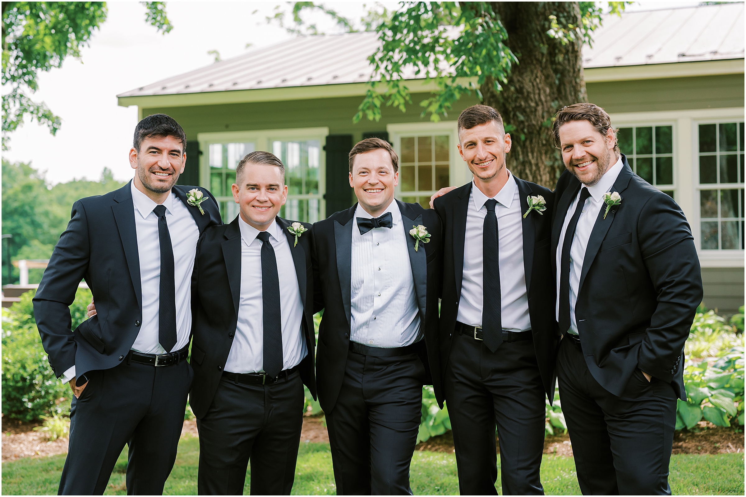 Groom with groomsmen wearing classic black suits and ties