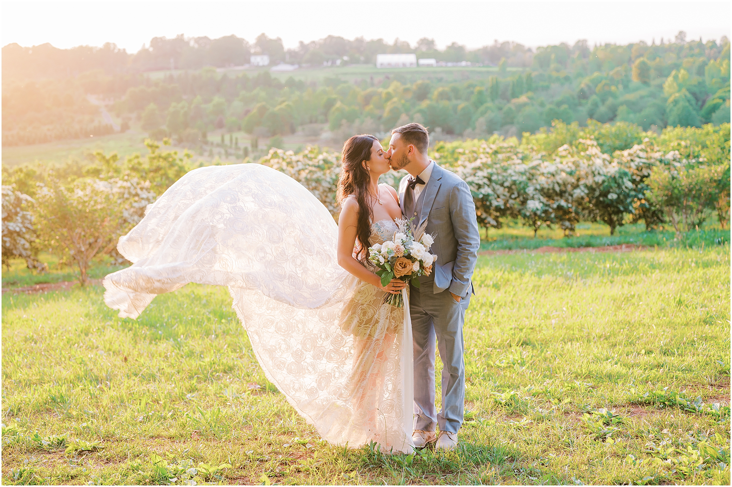 Kiss between bride and groom with dress blowing in the wind